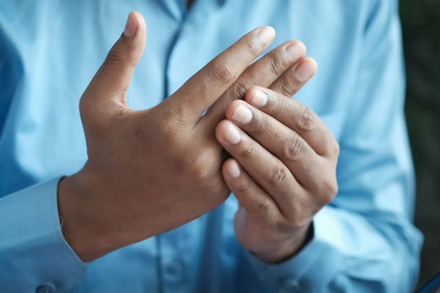 Close up of a man's hands, one rubbing the fingers of the other